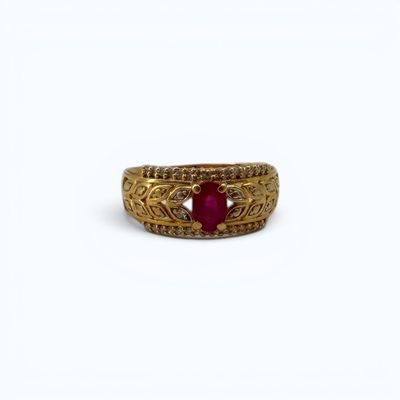 gros plan d'une bague en or avec une pierre en rubis