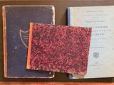 two old books sitting on top of a table next to each other