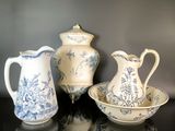 trois vases bleus et blancs et un bol posés sur une table
