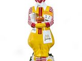 statue of a clown holding a plate of food in his hands