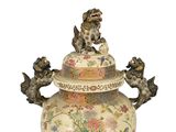 a large vase with a lion on top of it
