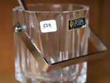 un verre contenant une cuillère, posé sur une étagère