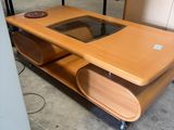 une table en bois avec un plateau en verre dans une pièce