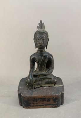 statue représentant une personne assise en position du lotus sur un bloc de bois