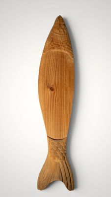 wooden fish sculpture on a wall with a white background