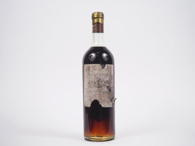 une vieille bouteille de whisky posée sur une surface blanche
