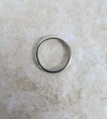 un gros plan d'une bague en argent posée sur une surface en marbre