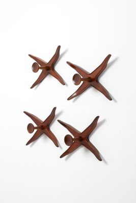 four pieces of wood are arranged in a circle on a white surface