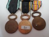 three medals and a medal are sitting on a white surface