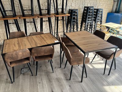 des tables et des chaises dans une pièce avec un mur en briques en arrière-plan