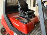 un chariot élévateur rouge avec un siège noir dans un garage