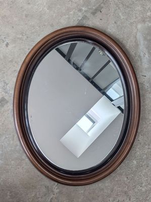 un miroir rond accroché au mur à côté d'un escalier