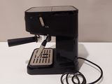 a small black coffee machine on a white table