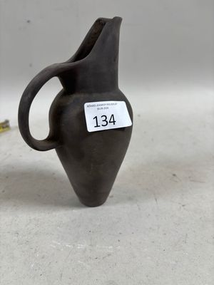 un petit vase noir sur lequel est accrochée une étiquette de prix