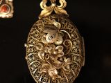 a close up of a pair of earrings on a black surface