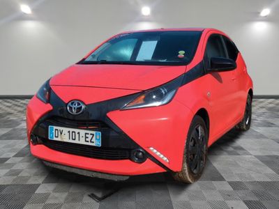 une Toyota AY rouge sur le sol en damier d'un garage