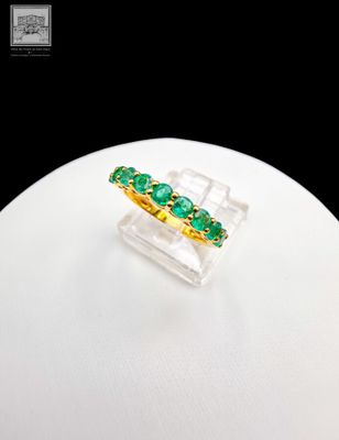 an image of a ring with green stones on it