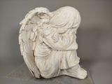 a white statue of an angel sitting on a table