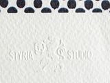 a close up of a white card with black dots on it