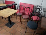 many chairs and tables in a restaurant with red seats