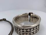 silver bracelet and a spoon on a white table
