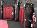 a lot of boxing bags hanging from the wall