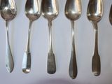 five spoons that are lined up on a table