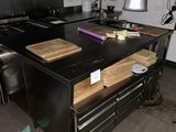 a kitchen with a black counter top and a wooden bench