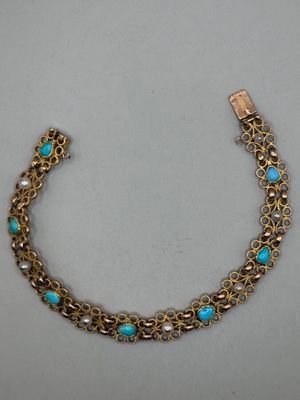 un bracelet en or orné de perles de turquoise et muni d'un fermoir en or