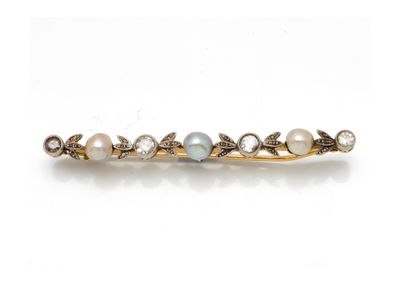 un gros plan sur une épingle à cheveux ornée d'une perle et d'un diamant