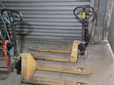 two forklifts sitting next to each other in a garage