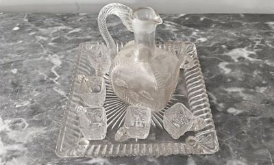un pichet en verre transparent posé sur un plateau, lui-même posé sur une table en marbre