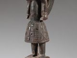 une image représentant une statue en bois d'un homme portant un casque sur la tête