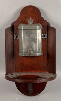 a wooden wall mounted clock with a silver plate on it