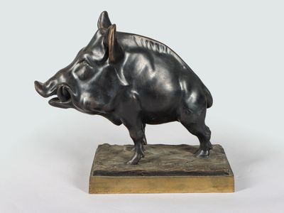 bronze sculpture of a boar on a wooden base on a white background
