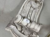 une statue représentant une femme tenant un bébé sur une chaise