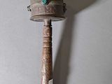 a small wooden mallet with a green stone on it