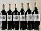 six bottles of wine are lined up in a row on a table