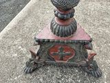 a metal pole with a clock on it on the side of the street
