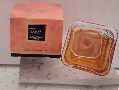 un flacon de parfum posé sur une boîte