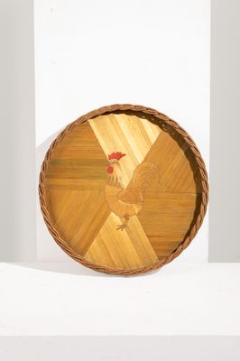 une assiette en bois sur laquelle est représenté un coq, posée sur une étagère