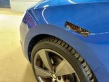 a close up of a blue car with a sticker on it