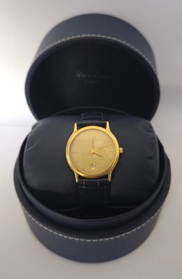 une image représentant une montre en or dans un écrin noir posé sur une surface blanche