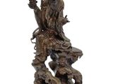 statue of a man sitting on a rock holding a pipe