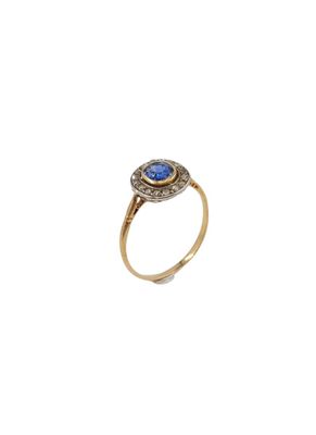 gros plan d'une bague en or avec une pierre bleue
