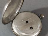 an old silver pocket watch sitting on top of a table