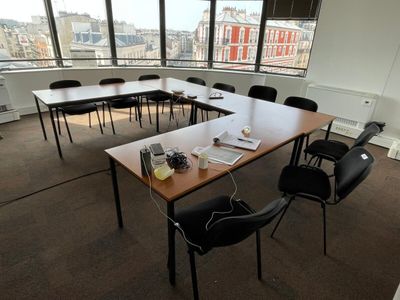 des tables et des chaises dans une pièce avec vue sur la ville