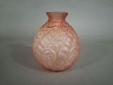 a pink glass vase sitting on a white surface