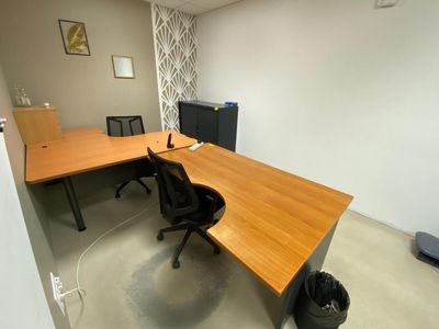 un bureau avec une chaise et un écran d'ordinateur dans un coin
