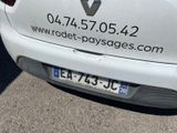 the back end of a white car parked in a parking lot